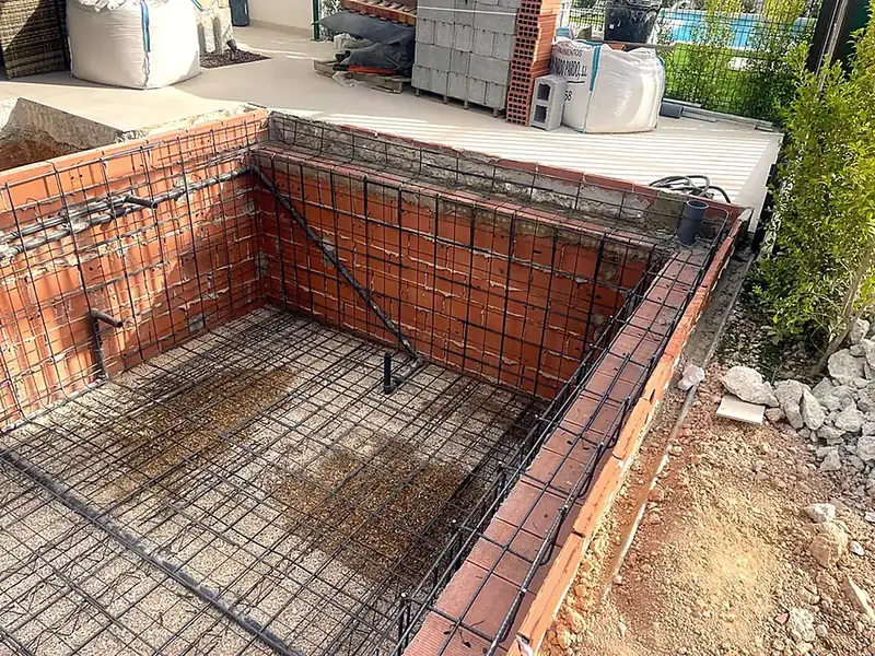 Concrete pool under construction, ceramic block shell with steel reinforcement mesh on walls and floor before the pour